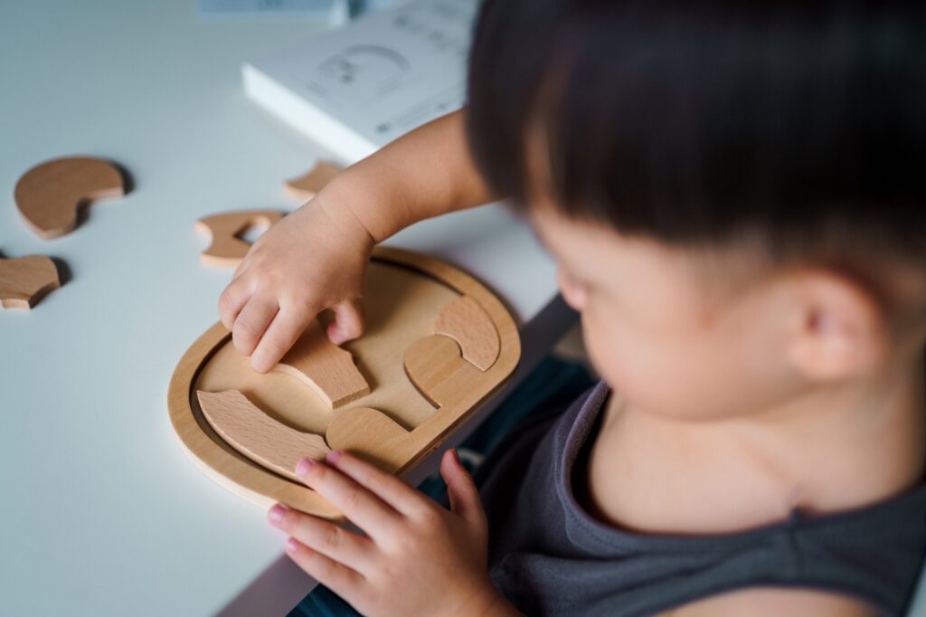 A child is playing with wooden puzzles.