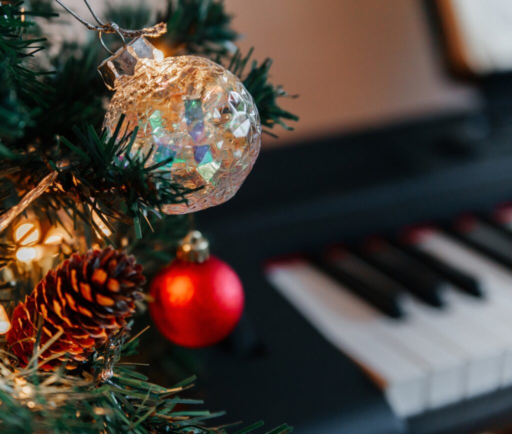 branches of a decorated Christmas tree on the background of piano keys.